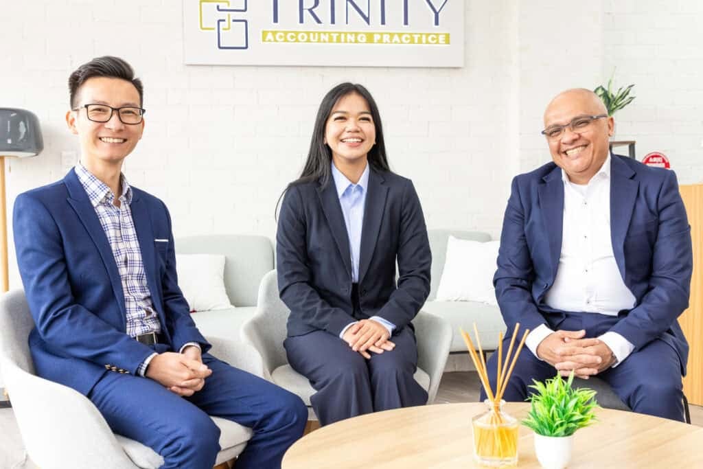 Dedicated team members in business attire smiling during a client consultation at the office.