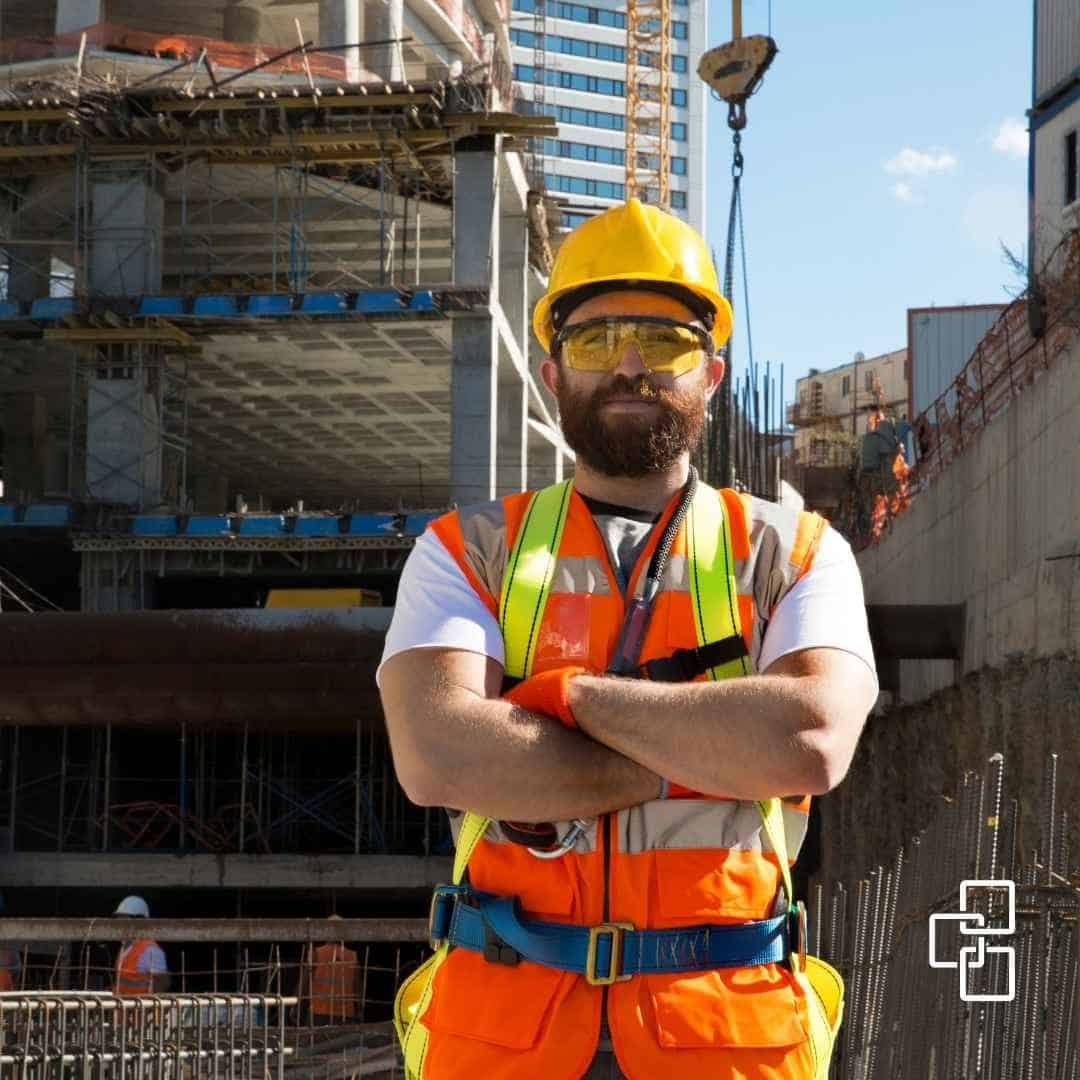 construction worker on commercial building site wearing safety vest and hard hat in australia