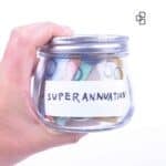 Hand holding a glass jar labeled "Superannuation" filled with Australian dollar notes, symbolising savings and tax refunds for retirement planning.