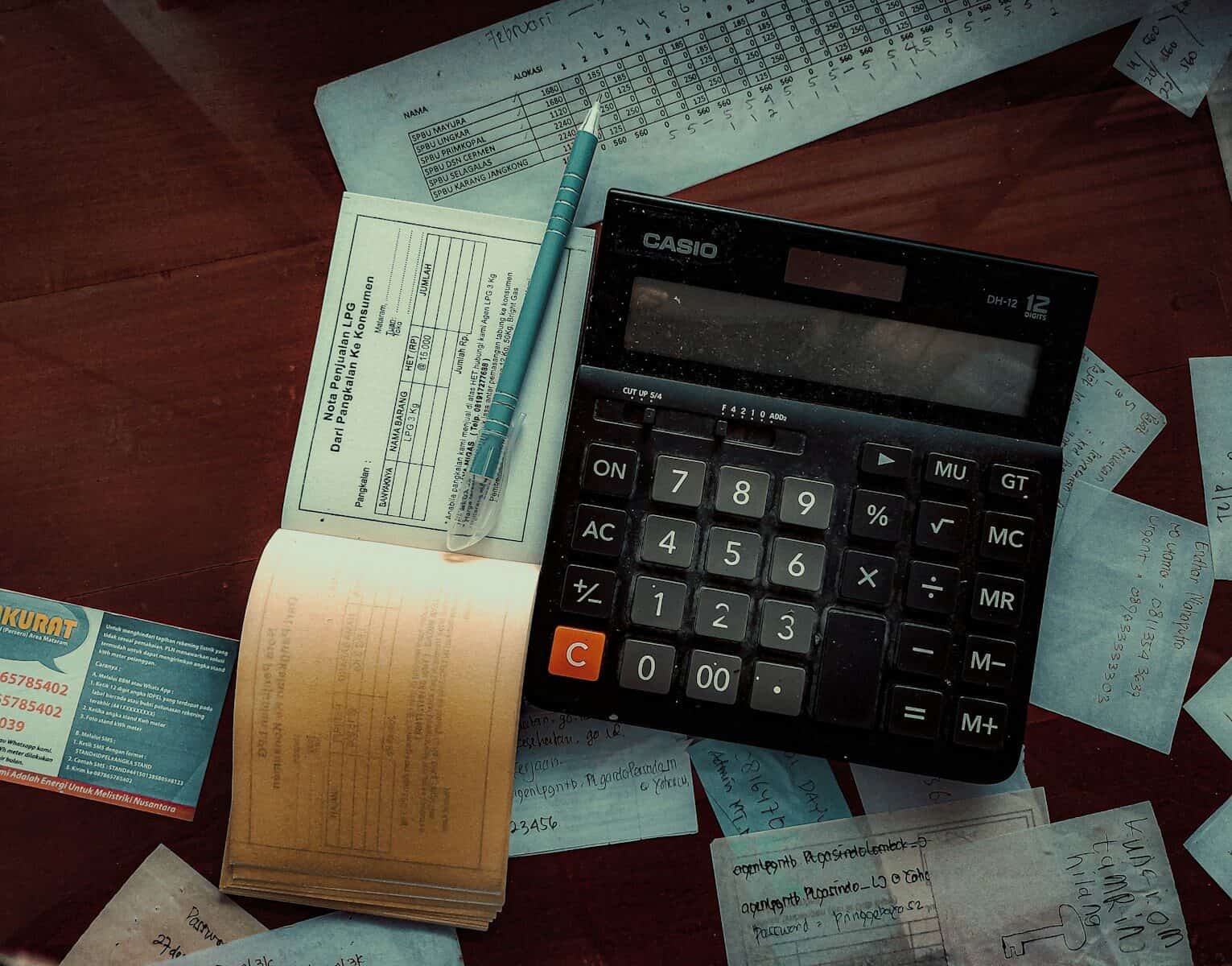 Ledger book, calculator and receipts on a desk, representing small business bookkeeping in Sydney