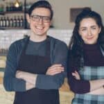 Two small business owners standing in their shop, representing preparing a business for sale