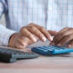 Employer at a desk calculating payroll, representing payday super obligations from 1 July 2026