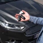 Hand holding car keys over a car, representing car write-off rules for Australian businesses