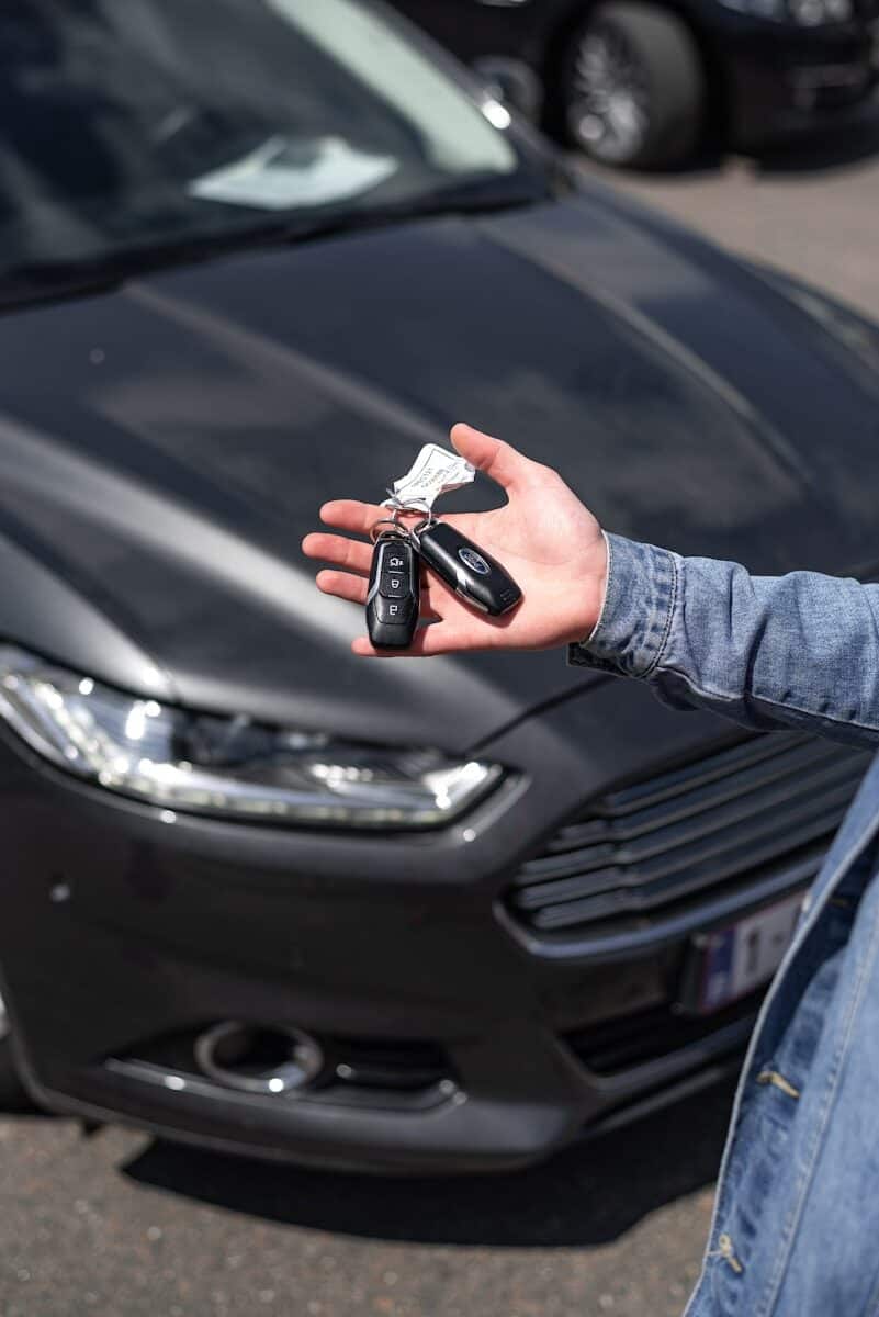 Hand holding car keys over a car, representing car write-off rules for Australian businesses